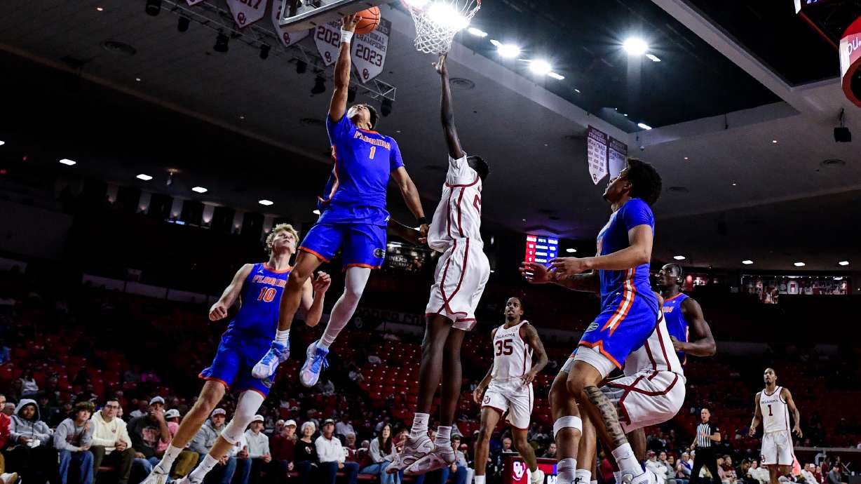 Florida guard Xaivian Lee (1) shoots against Oklahoma forward Kuol Atak (22) during the first half of an NCAA college basketball game, Tuesday, Jan. 13, 2026, in Norman, Okla.