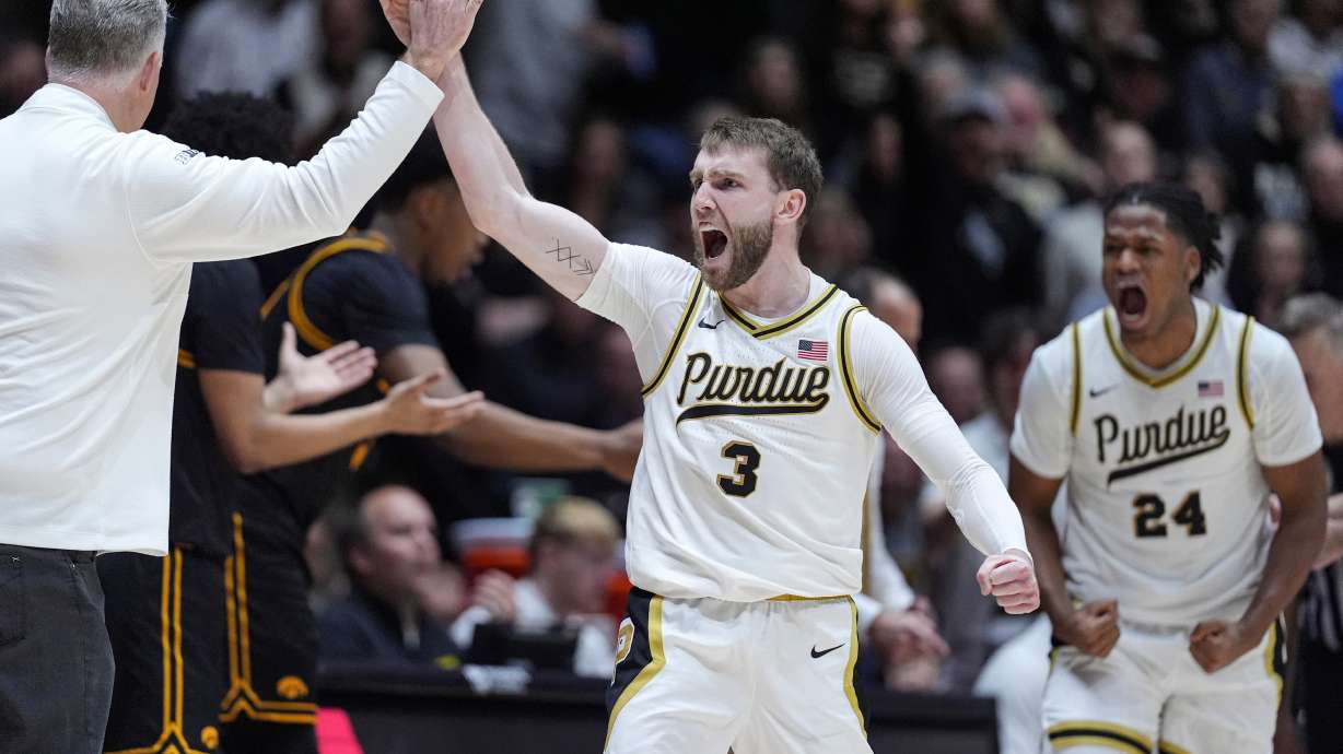 Purdue guard Braden Smith (3) high-fives head coach Matt Painter, left, after forcing a turnover against Iowa during the second half of an NCAA college basketball game in West Lafayette, Ind., Wednesday, Jan. 14, 2026.