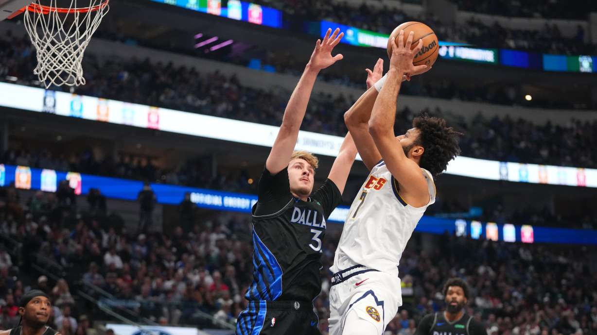 Denver Nuggets guard Jamal Murray, right, goes up for a basket against Dallas Mavericks forward Cooper Flagg during the first half of an NBA basketball game Wednesday, Jan. 14, 2026, in Dallas.