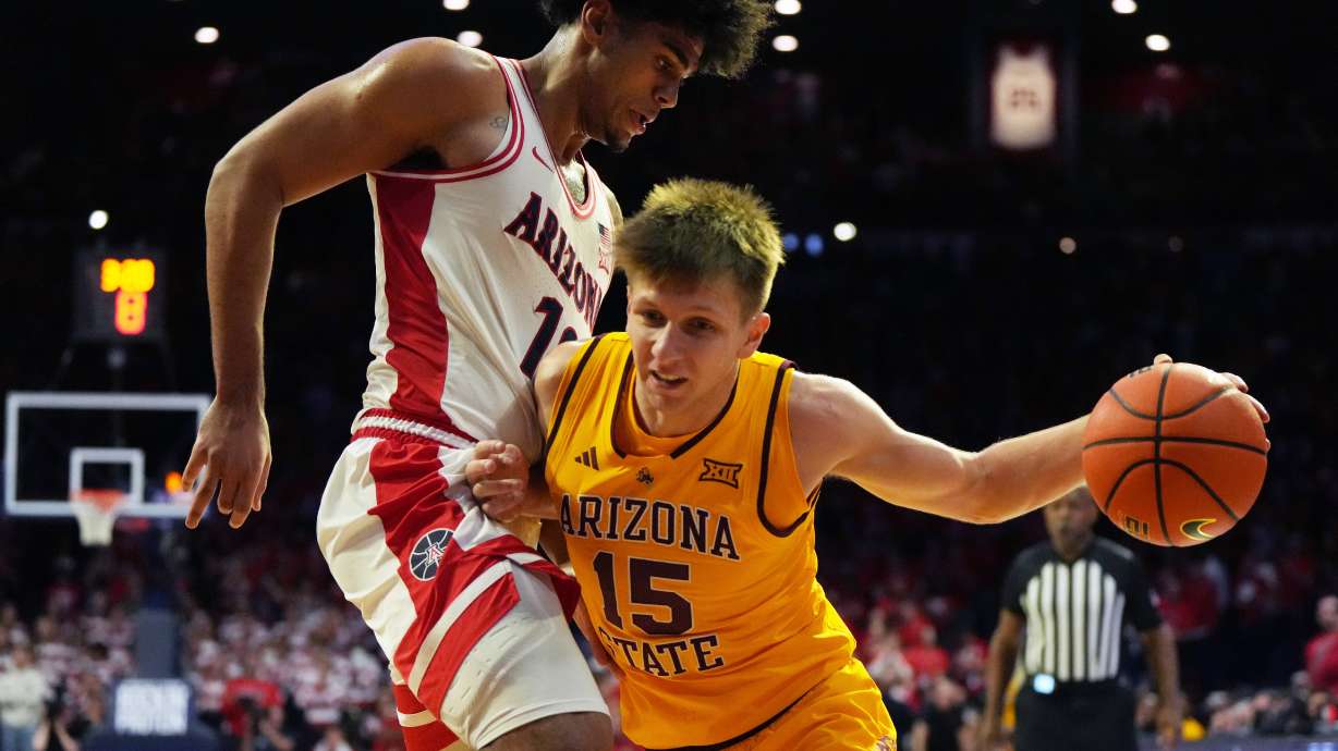 Arizona State guard Noah Meeusen (15) drives on Arizona forward Koa Peat during the first half of an NCAA college basketball game, Wednesday, Jan. 14, 2026, in Tucson, Ariz.