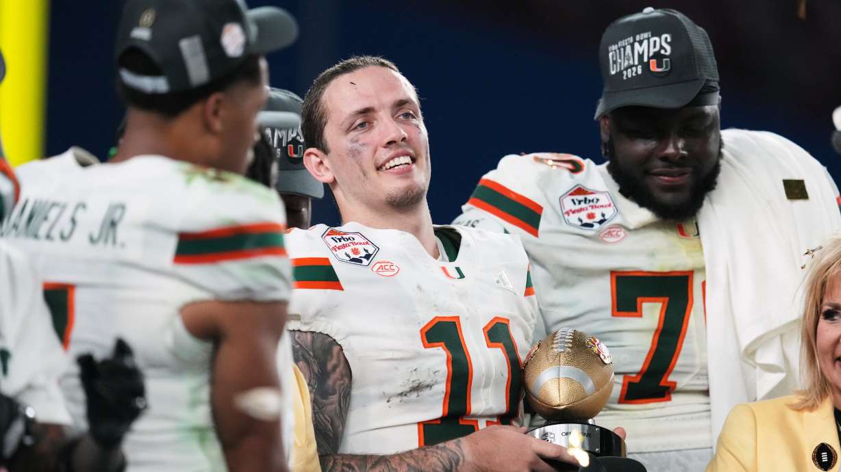 Miami quarterback Carson Beck (11) holds the offensive player of the game trophy after winning the Fiesta Bowl NCAA college football playoff semifinal game against Mississippi, Thursday, Jan. 8, 2026, in Glendale, Ariz.