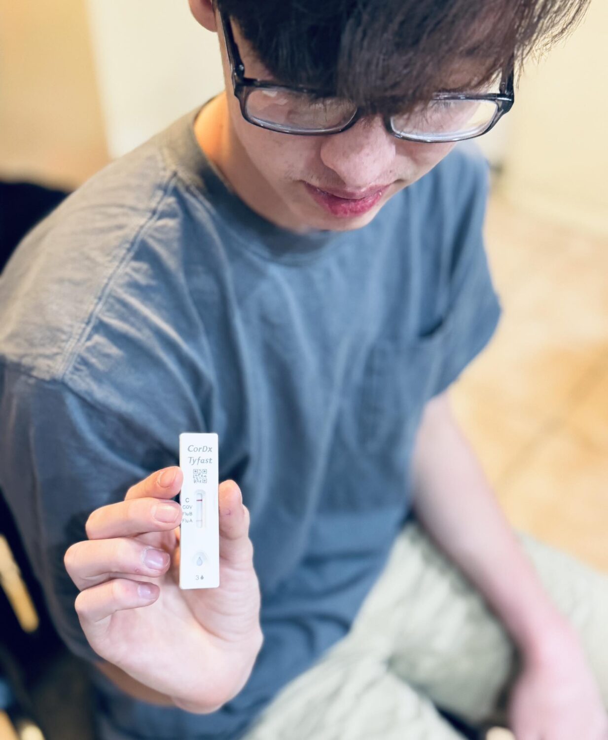 One of the Hubbard family's children holds up a positive test for the flu. Three of the seven Hubbard children tested positive for the flu over their Christmas break.