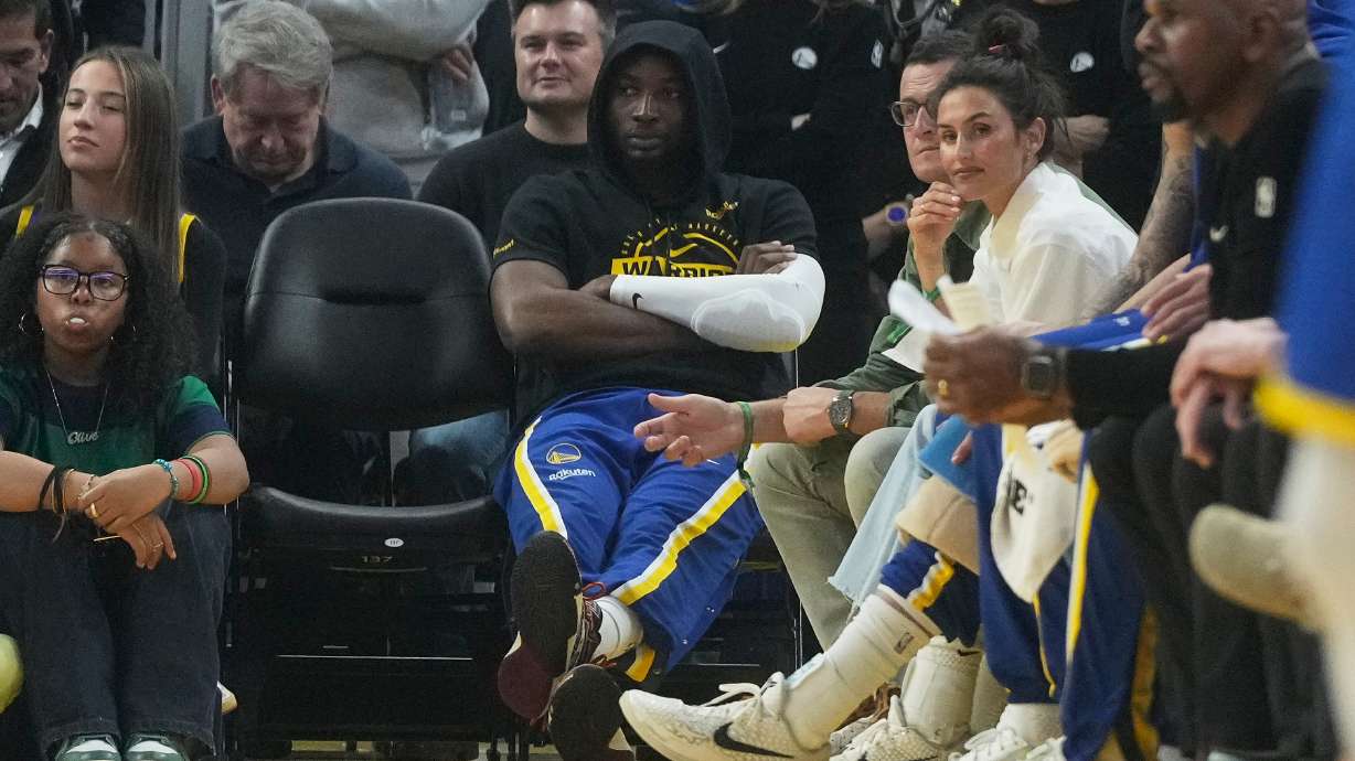 Golden State Warriors forward Jonathan Kuminga, middle, sits near the team bench during the first half of an NBA basketball game against the New York Knicks in San Francisco, Thursday, Jan. 15, 2026.