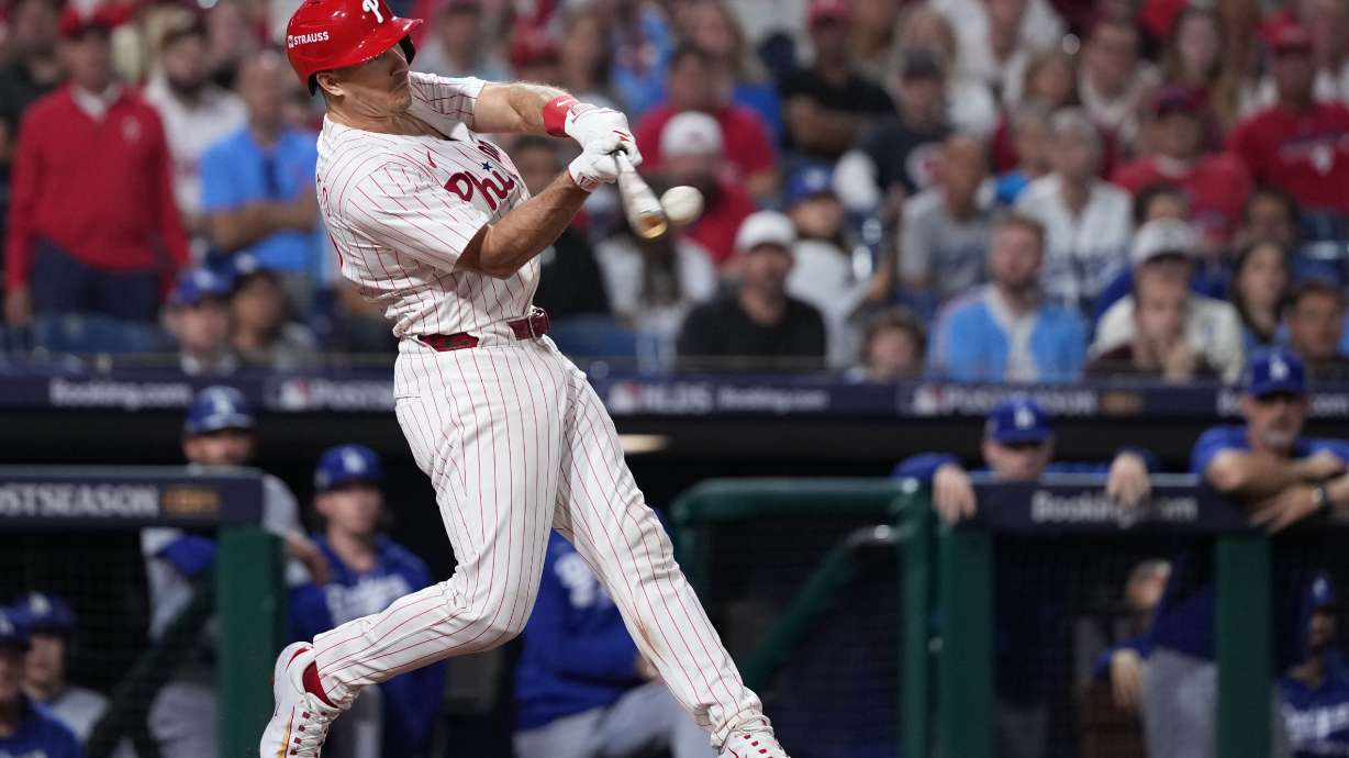 FILE - Philadelphia Phillies' J.T. Realmuto hits a double during the ninth inning in Game 2 of baseball's National League Division Series against the Los Angeles Dodgers, Monday, Oct. 6, 2025, in Philadelphia.