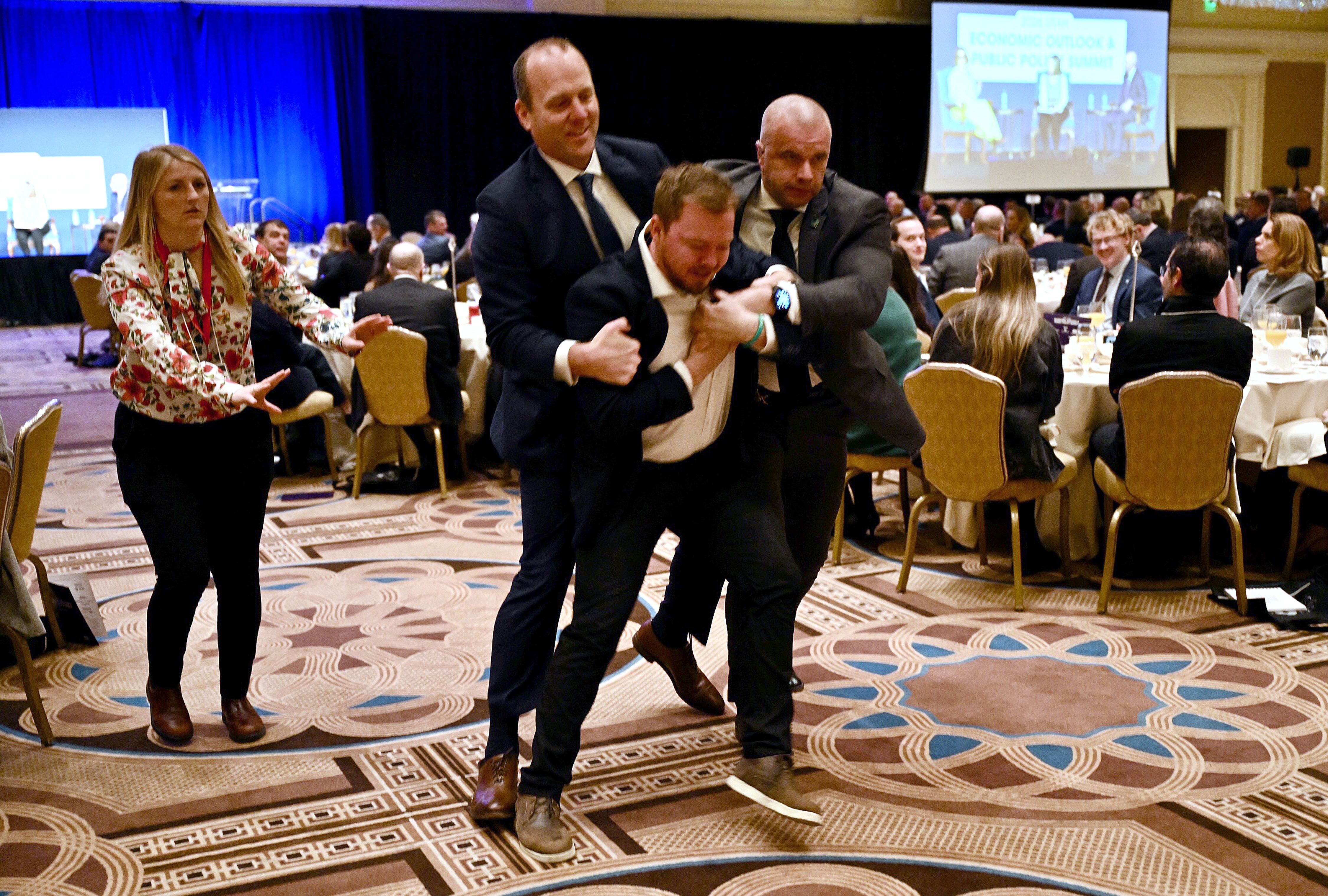 A protester is removed by security after heckling former Arizona Sen. Kyrsten Sinema during the the 2026 Utah Economic Outlook & Public Policy Summit at the Grand America in Salt Lake City, Friday. Sinema's appearance came a day after a lawsuit was filed against her.