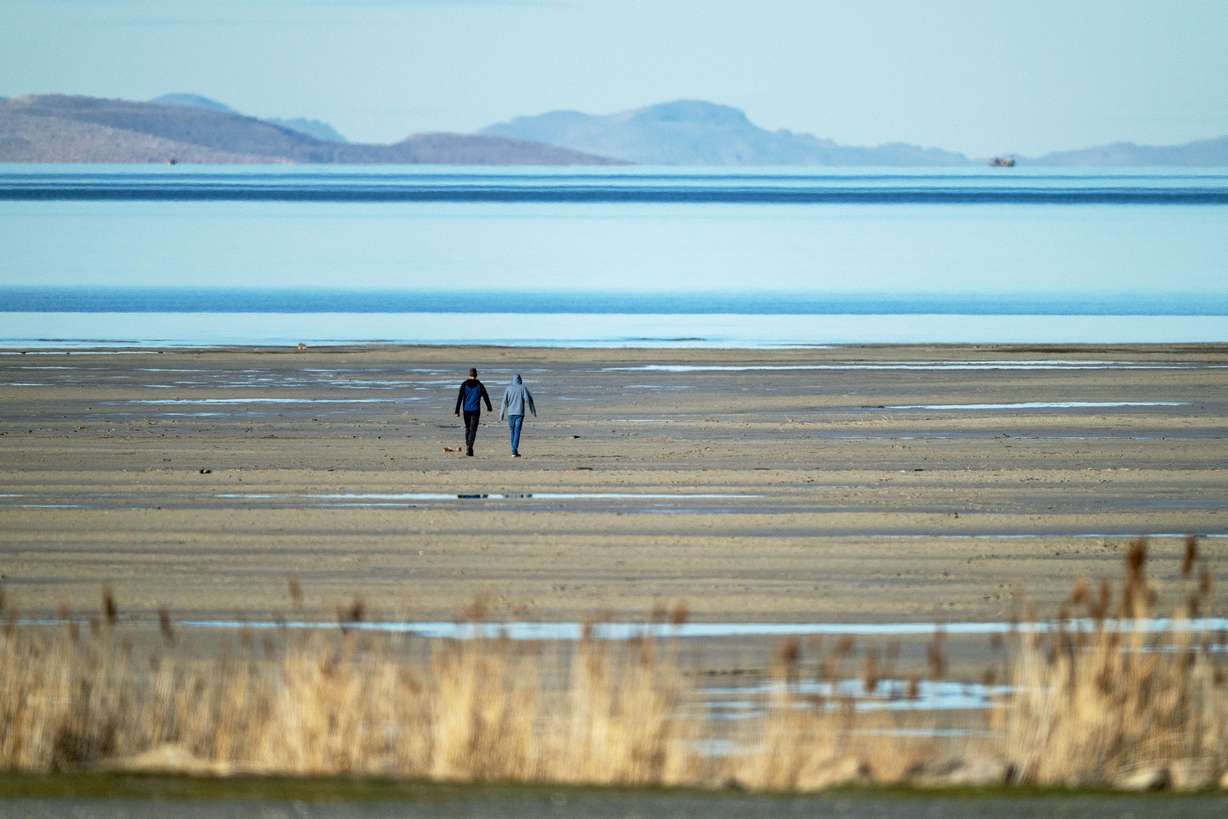 Two people walk toward the water on the sand bar at the Great Salt Lake near Magna on Jan. 6.