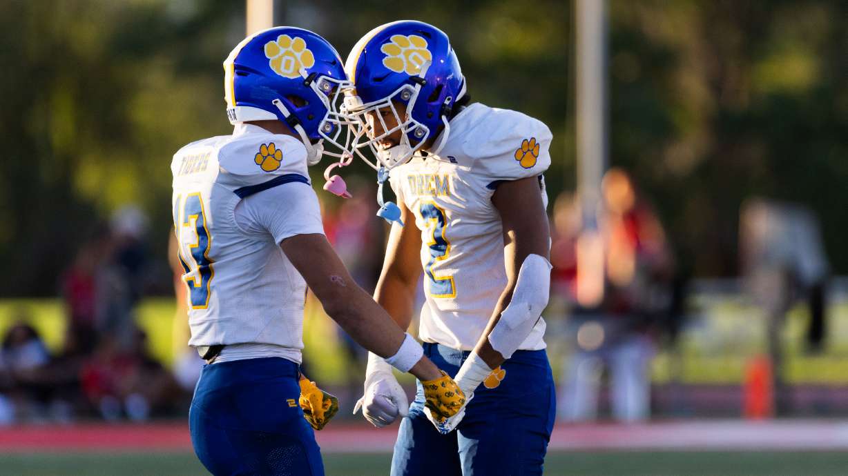 Orem’s Kaue Akana and Roger Saleapaga celebrate during their high school football season opener against East at East High School in Salt Lake City on Friday, Aug. 11, 2023. Orem won the game 21-20.