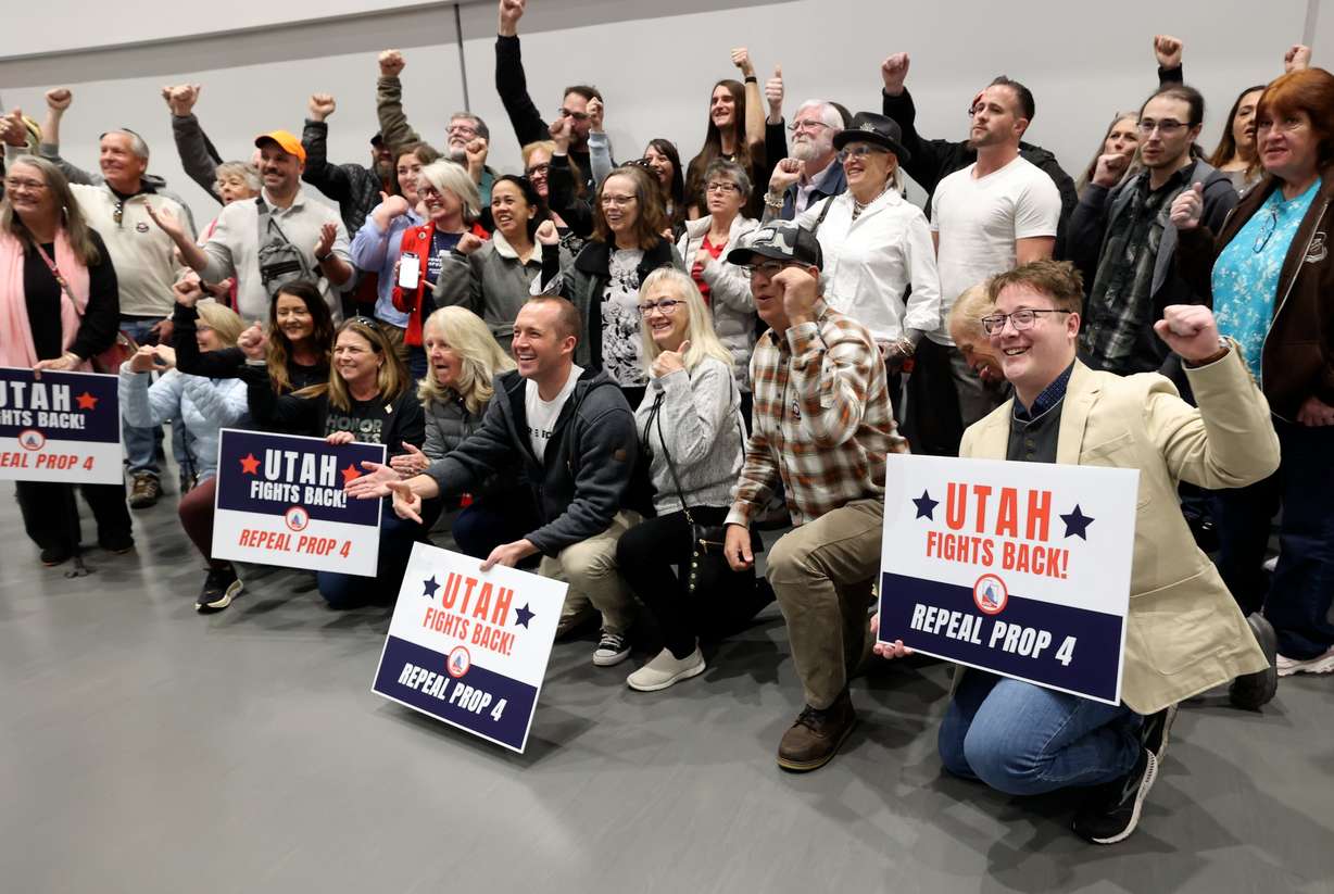 Attendees pose for a photo with Scott Presler, a Republican voter mobilization activist, at the Weber County Fights Back Rally at the Roy Library in Roy on Friday, Jan. 16, 2026.