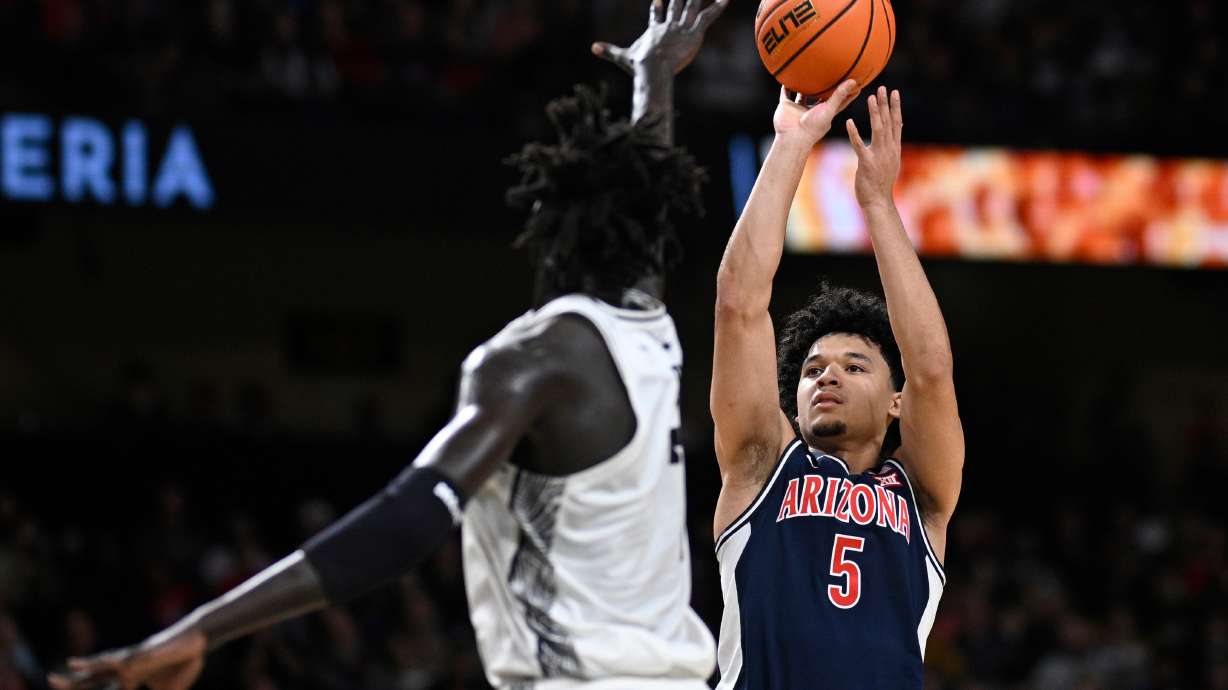 Arizona guard Brayden Burries (5) goes up to shoot as Central Florida center John Bol (7) defends during the first half of an NCAA college basketball game, Saturday, Jan. 17, 2026, in Orlando, Fla.