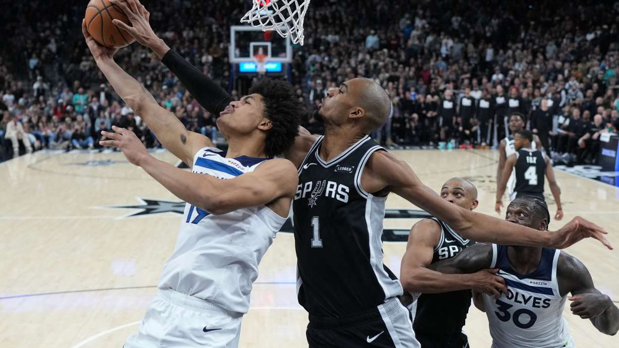 Minnesota Timberwolves forward Joan Beringer (19) is blocked by San Antonio Spurs forward Victor Wembanyama (1) as he drives to the basket during the second half of an NBA basketball game in San Antonio, Saturday, Jan. 17, 2026.