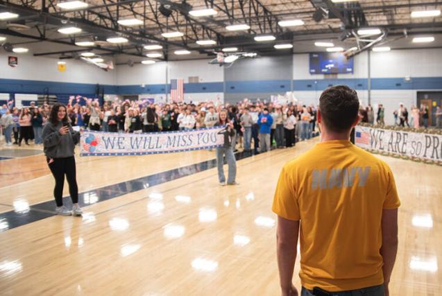 Sean Steo enters the gymnasium at Eagle Rock Middle School where students are gathered for a surprise send-off.