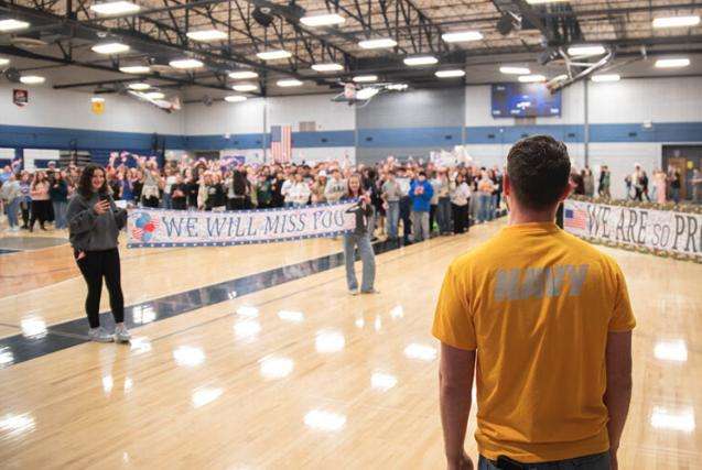 Sean Steo enters the gymnasium at Eagle Rock Middle School where students are gathered for a surprise send-off.