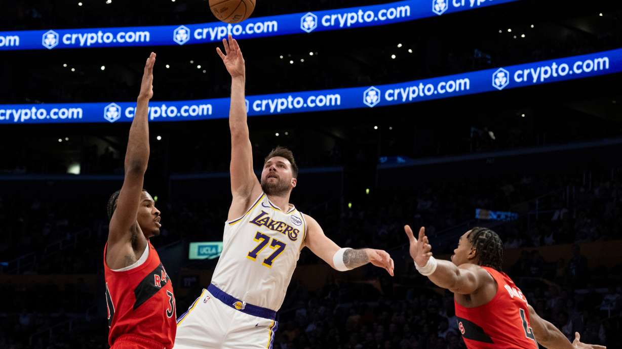 Los Angeles Lakers guard Luka Doncic (77) shoots over Toronto Raptors guard Ochai Agbaji (30) during the first half of an NBA basketball game in Los Angeles, Sunday, Jan. 18, 2026.