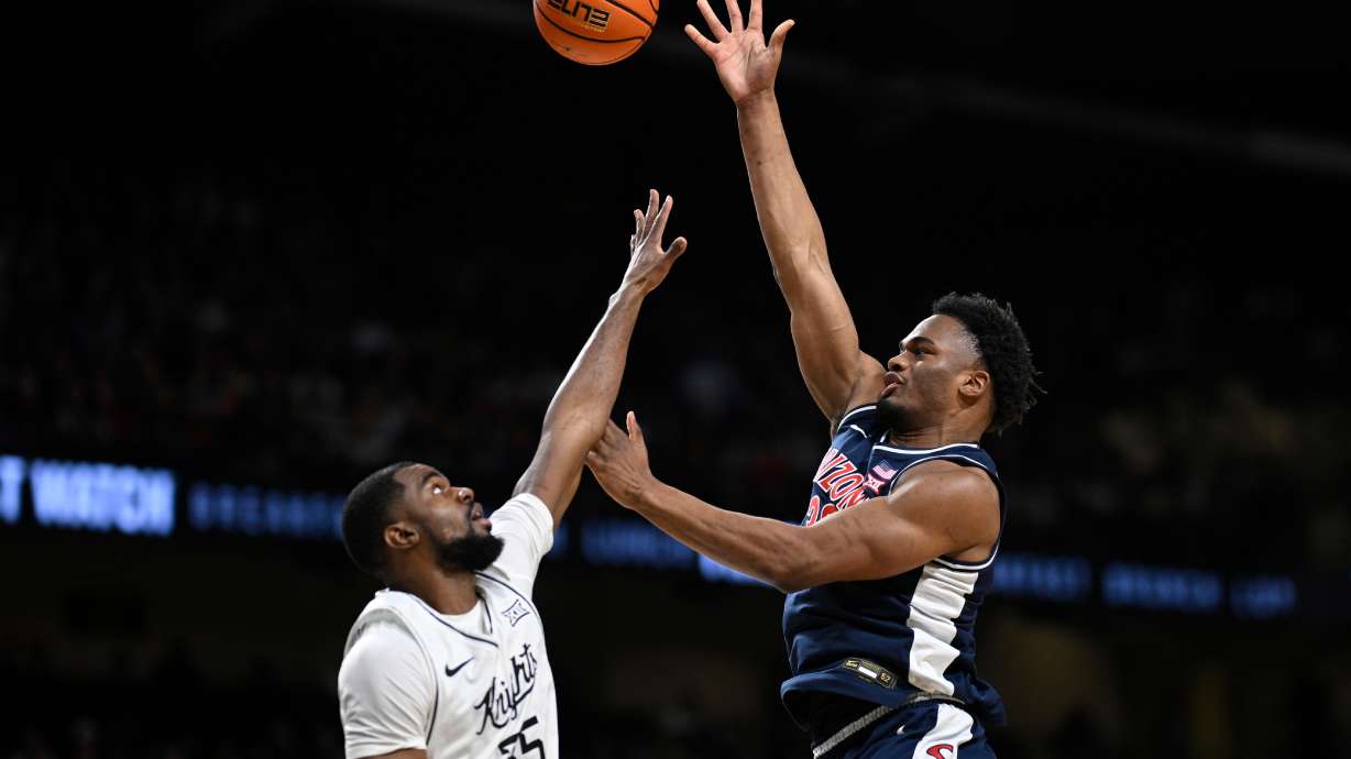 Arizona forward Tobe Awaka, right, shoots as Central Florida forward Devan Cambridge (35) defends during the first half of an NCAA college basketball game, Saturday, Jan. 17, 2026, in Orlando, Fla.