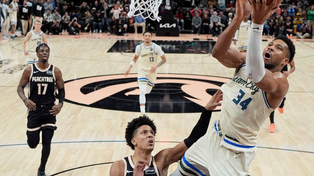 Milwaukee Bucks forward Giannis Antetokounmpo (34) shoots against Atlanta Hawks forward Jalen Johnson (1) during the second half of an NBA basketball game, Monday, Jan. 19, 2026, in Atlanta.