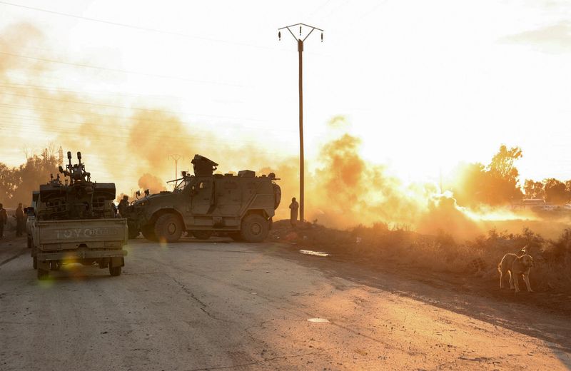 Military members gather near Raqqa prison, where the Syrian army is besieging SDF members after the Syrian army took control of the city of Raqqa, Syria, Monday.