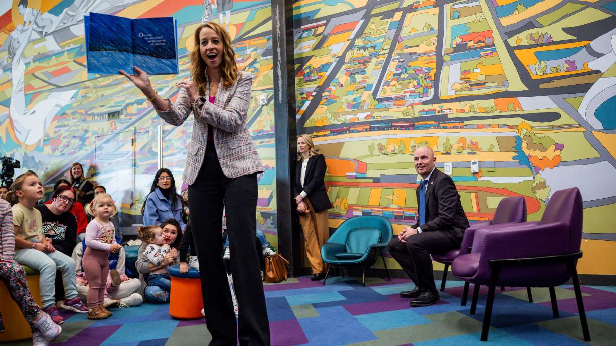 Gov. Spencer Cox, right, smiles as first lady Abby Cox reads to children after a press conference discussing the fiscal year 2026-27 budget rollout at Kearns Library in Kearns on Dec. 3, 2025.