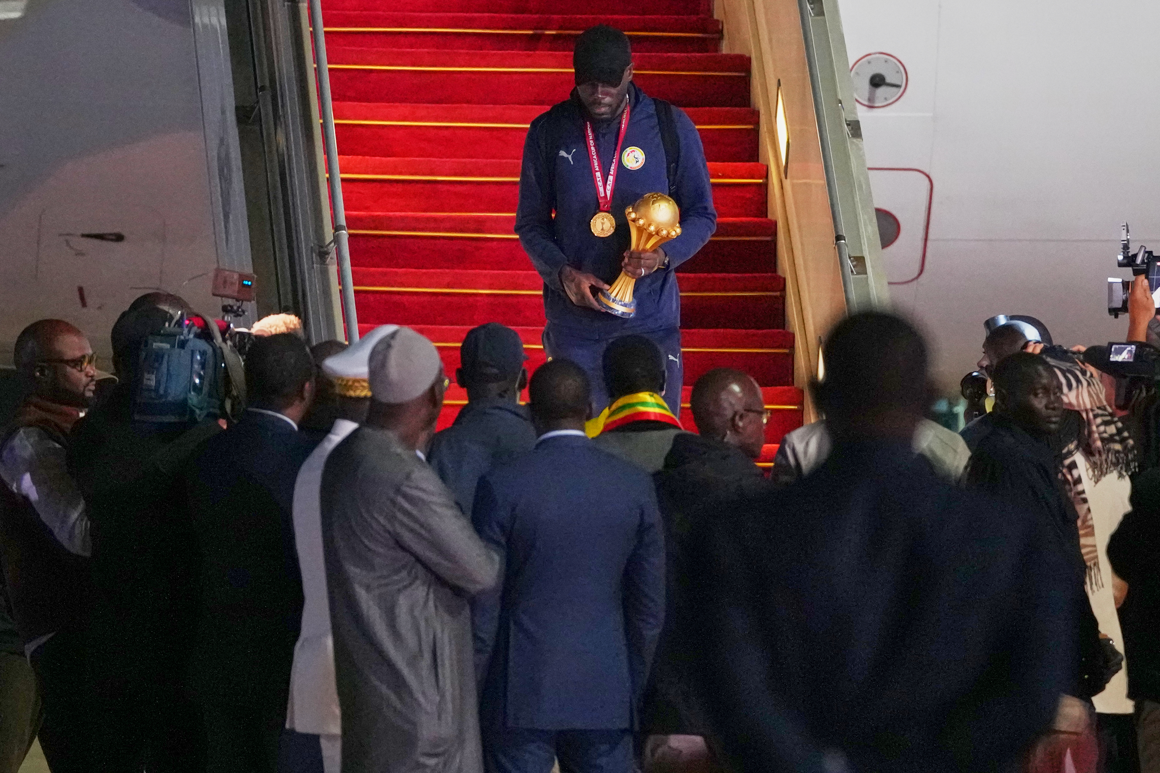 Senegal's Kalidou Koulibaly holds the Africa Cup of Nations trophy as he deplanes following their victory in the Africa Cup of Nations soccer tournament, in Ndiass, Senegal, Tuesday, Jan. 20, 2026. 