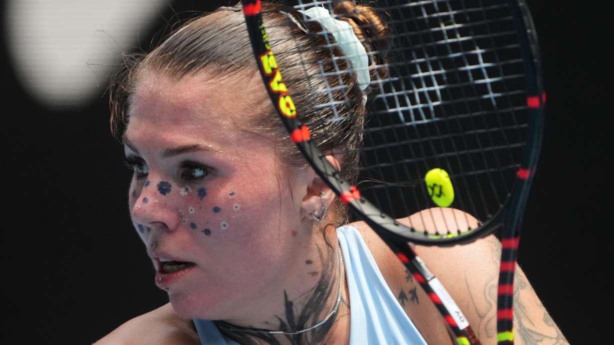 Oleksandra Oliynykova of Ukraine plays a backhand return to Madison Keys of the U.S. during their first round match at the Australian Open tennis championship in Melbourne, Australia, Tuesday, Jan. 20, 2026.