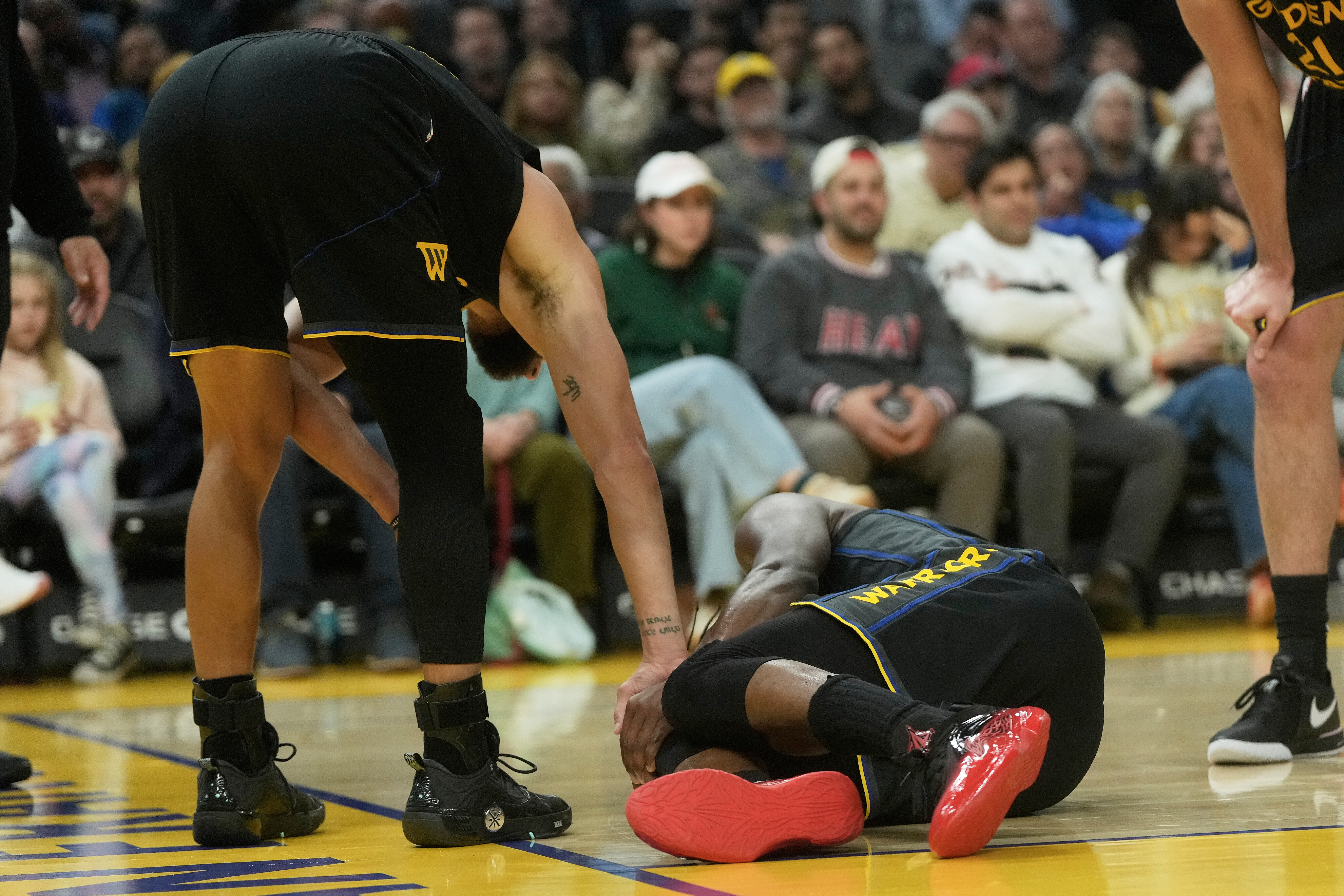 Golden State Warriors guard Stephen Curry, left, checks on forward Jimmy Butler III during the second half of an NBA basketball game against the Miami Heat in San Francisco, Monday, Jan. 19, 2026. 