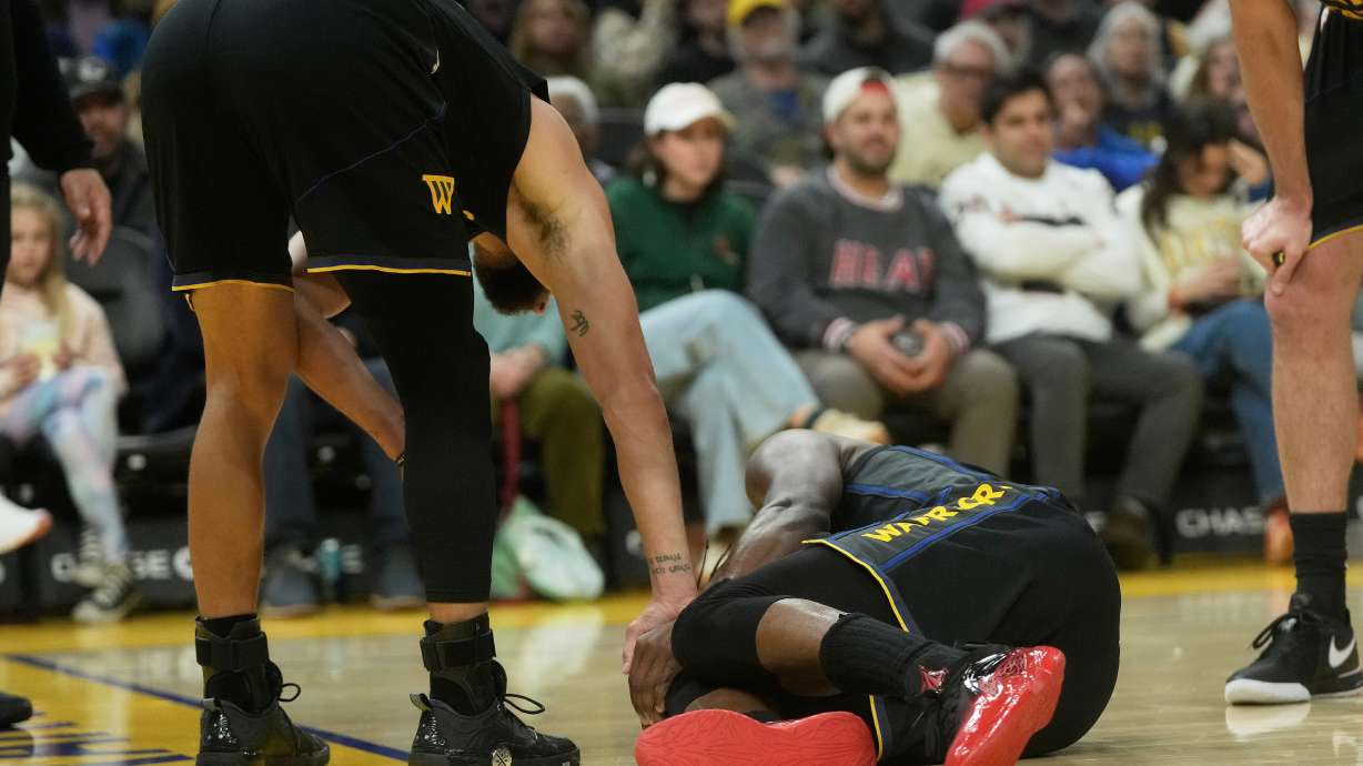 Golden State Warriors guard Stephen Curry, left, checks on forward Jimmy Butler III during the second half of an NBA basketball game against the Miami Heat in San Francisco, Monday, Jan. 19, 2026.