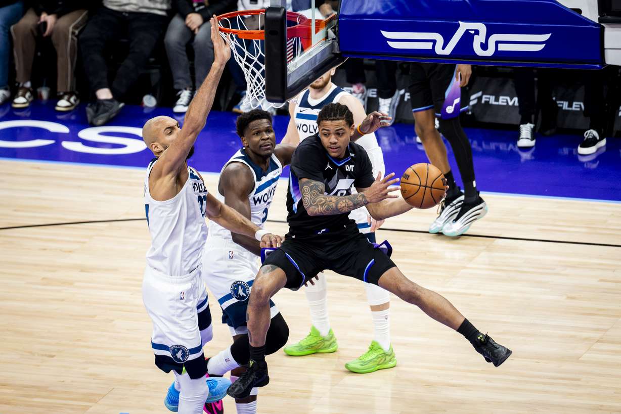 Utah Jazz guard Keyonte George (3) looks to pass the ball out mid-shot as he’s guarded by Minnesota Timberwolves center Rudy Gobert (27) and guard Anthony Edwards (5) during an NBA game held at the Delta Center in Salt Lake City on Tuesday, Jan. 20, 2026.