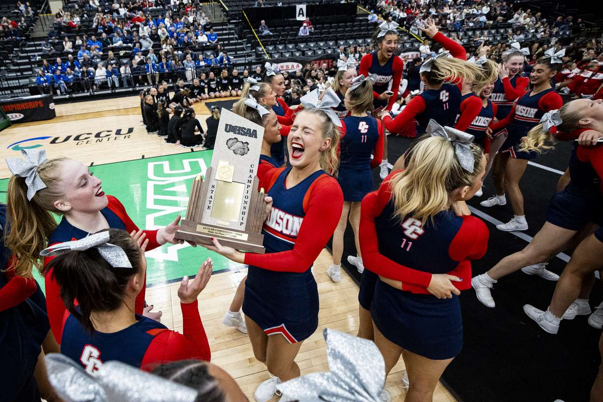 Cheerleaders from the Crimson Cliffs High School team celebrate with the championship trophy after being awarded first place overall in the co-ed competitive cheer category during the awards ceremony after the UHSAA 4A State Cheer Championships at the UCCU Center in Orem on Wednesday, Jan. 21, 2026.