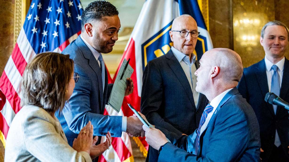 Utah Gov. Spencer Cox shakes hands with Rep. Doug Fiefia, R-Herriman, after signing a ceremonial copy of HB418, the Digital Choice Act, which Rep. Fiefia sponsored, during a press conference to address online safety, student focus and digital choice held in the gold room of the Capitol in Salt Lake City on April 4, 2025.