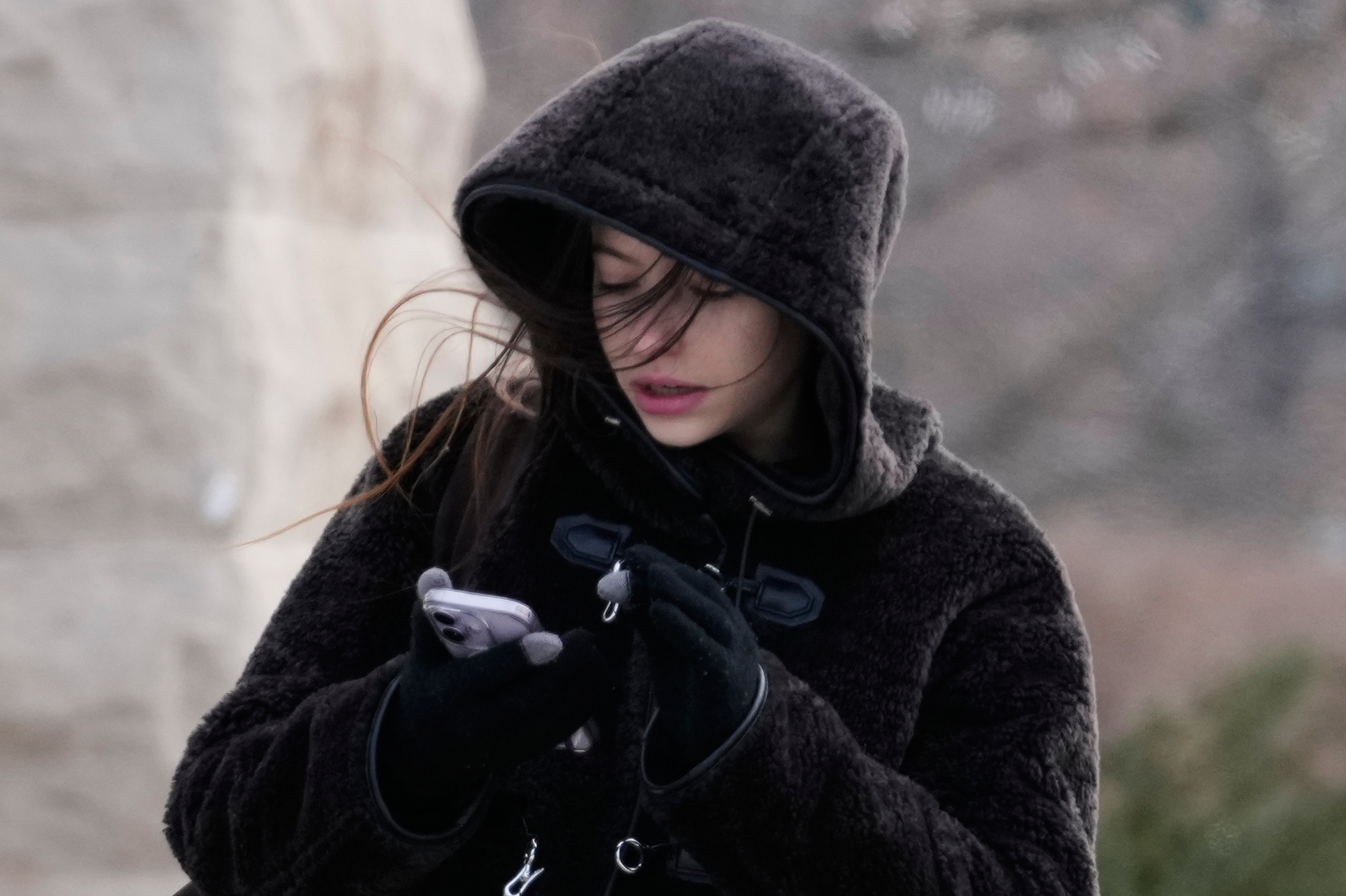 A pedestrian bundles up as she crosses a street during a cold weather day in Evanston, Ill., Thursday. At least 11 Southern states are expected to be hit by extreme cold, ice or snow.