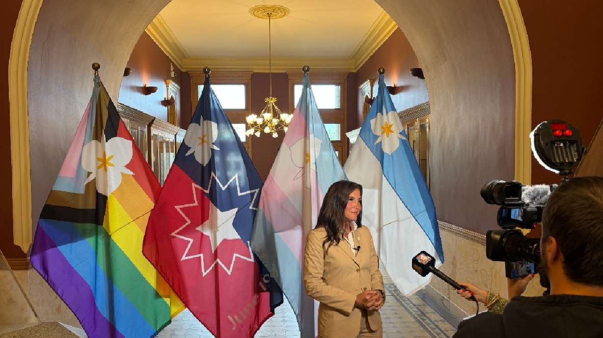 Salt Lake City Mayor Erin Mendenhall stands in front of three new city flags on May 6, 2025. A Utah lawmaker is proposing to limit secondary city flags from being flown in schools, airports and courthouses, hoping to end a flag fight that started last year.
