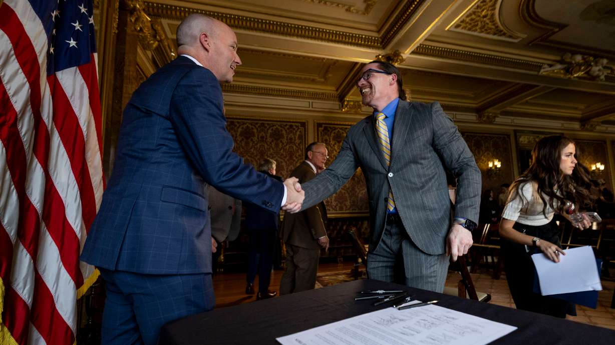 Gov. Spencer Cox shakes hands with Salt Lake Community College President Greg Peterson during a press conference for the signing of Utah’s Higher Education Resolution in the Gold Room of the Capitol in Salt Lake City on Friday.