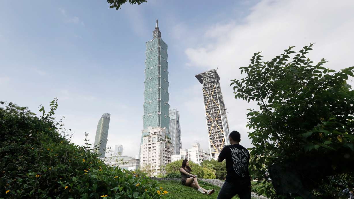 FILE - People take photos with the iconic Taipei 101 skyscraper in the background in Taipei, Taiwan, April 27, 2025.
