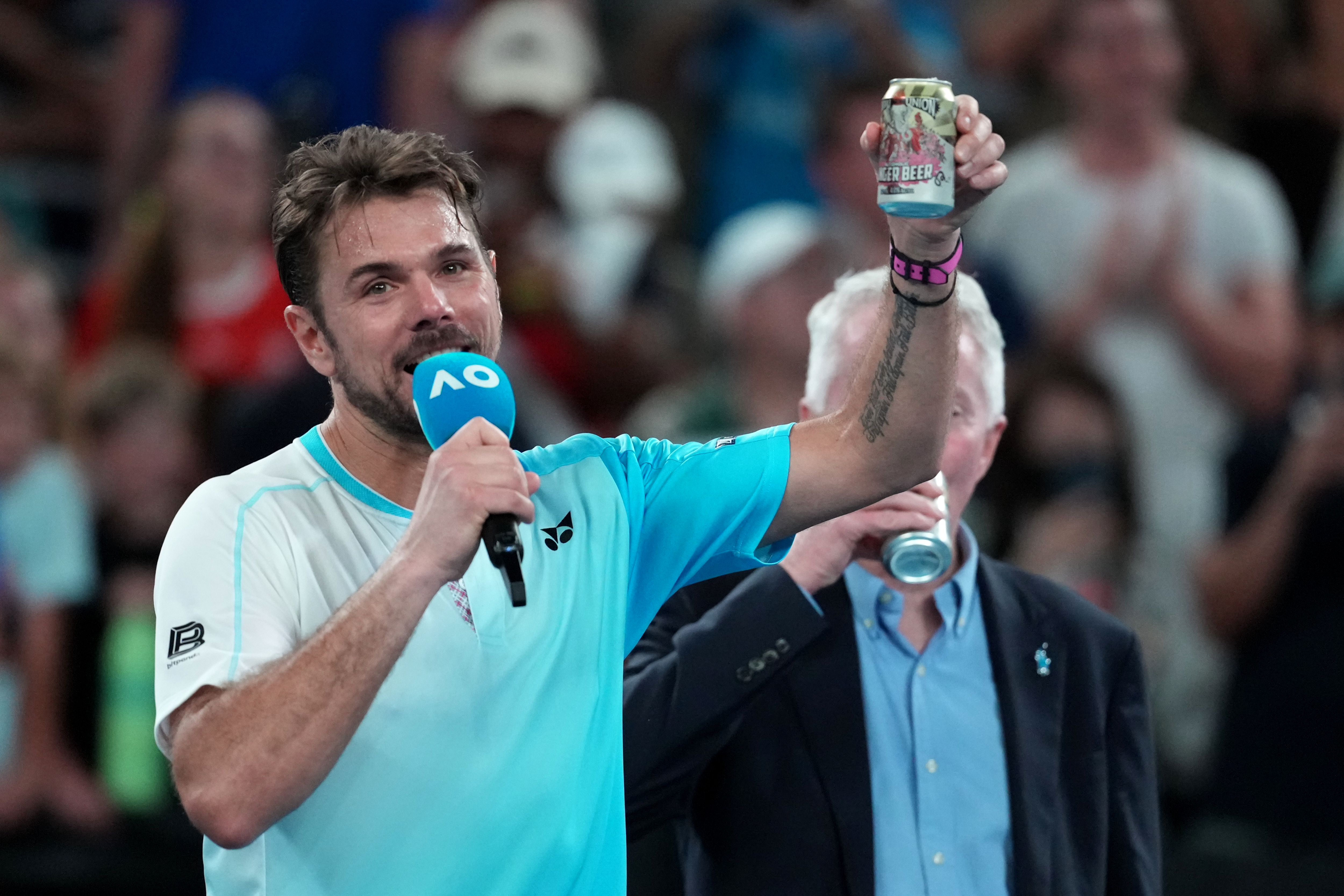 Stan Wawrinka of Switzerland holds up a beer following his third round loss to Taylor Fritz of the U.S. at the Australian Open tennis championship in Melbourne, Australia, Saturday, Jan. 24, 2026. 