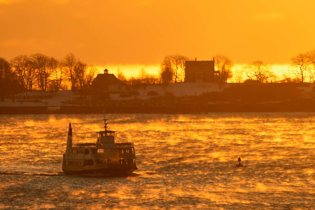 Sea smoke rises from Casco Bay at sunrise on a 1-degree morning as a ferry boat makes its way to Portland, Maine, Saturday. Eastern states officials are warning of major damage from a winter storm sweeping across the country.