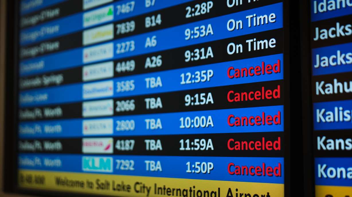 A flight status screen shows canceled flights to the Dallas-Fort Worth, Texas, area from the Salt Lake City International Airport amid a winter storm, Saturday in Salt Lake City. Thousands of flights have been disrupted and thousands more are without power as a monster winter storm barrels across the U.S.