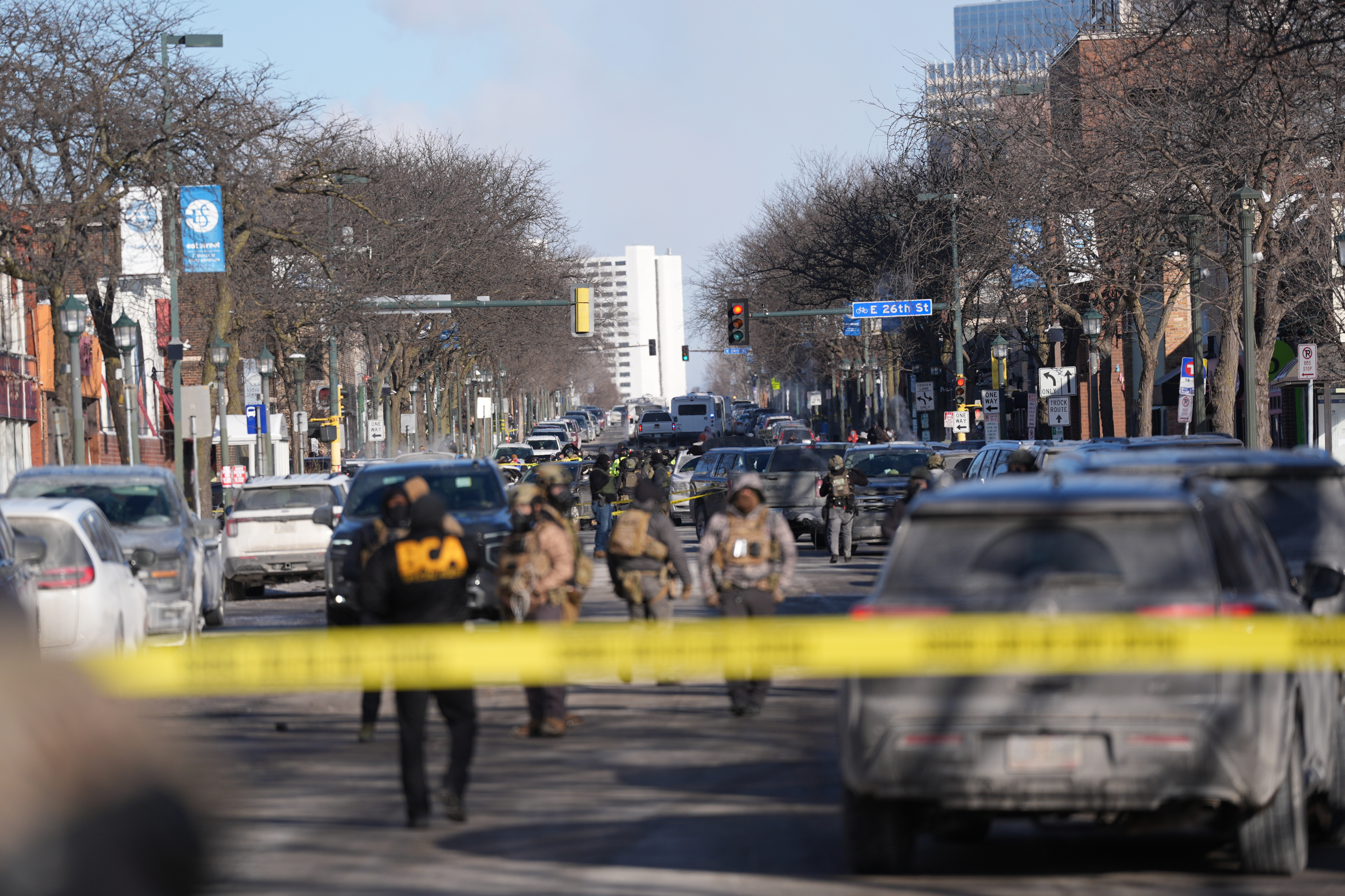 Federal agents stand near the site of a shooting Saturday in Minneapolis.