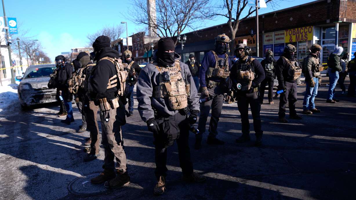 Federal agents stand near the site of a shooting Saturday in Minneapolis.