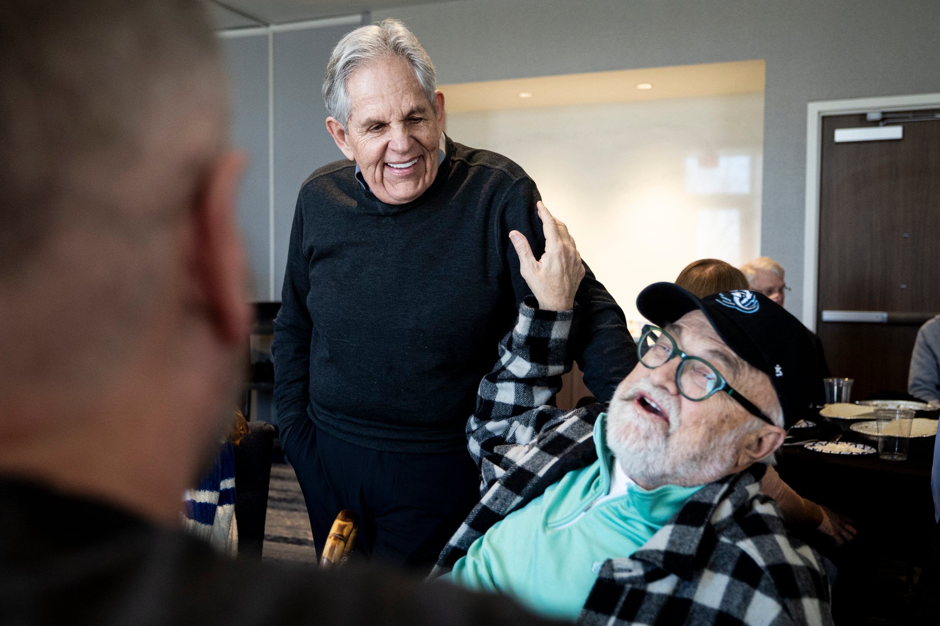 Jeffrey K. Woodbury, right, senior vice president of development and acquisitions for Woodbury Corporation, pats Rob Kallas, outgoing general manager for University Place, as Woodbury tells another attendee about Kallas during a retirement party for Kallas, held at the Courtyard by Marriott Orem University Place hotel on Jan. 15,.
