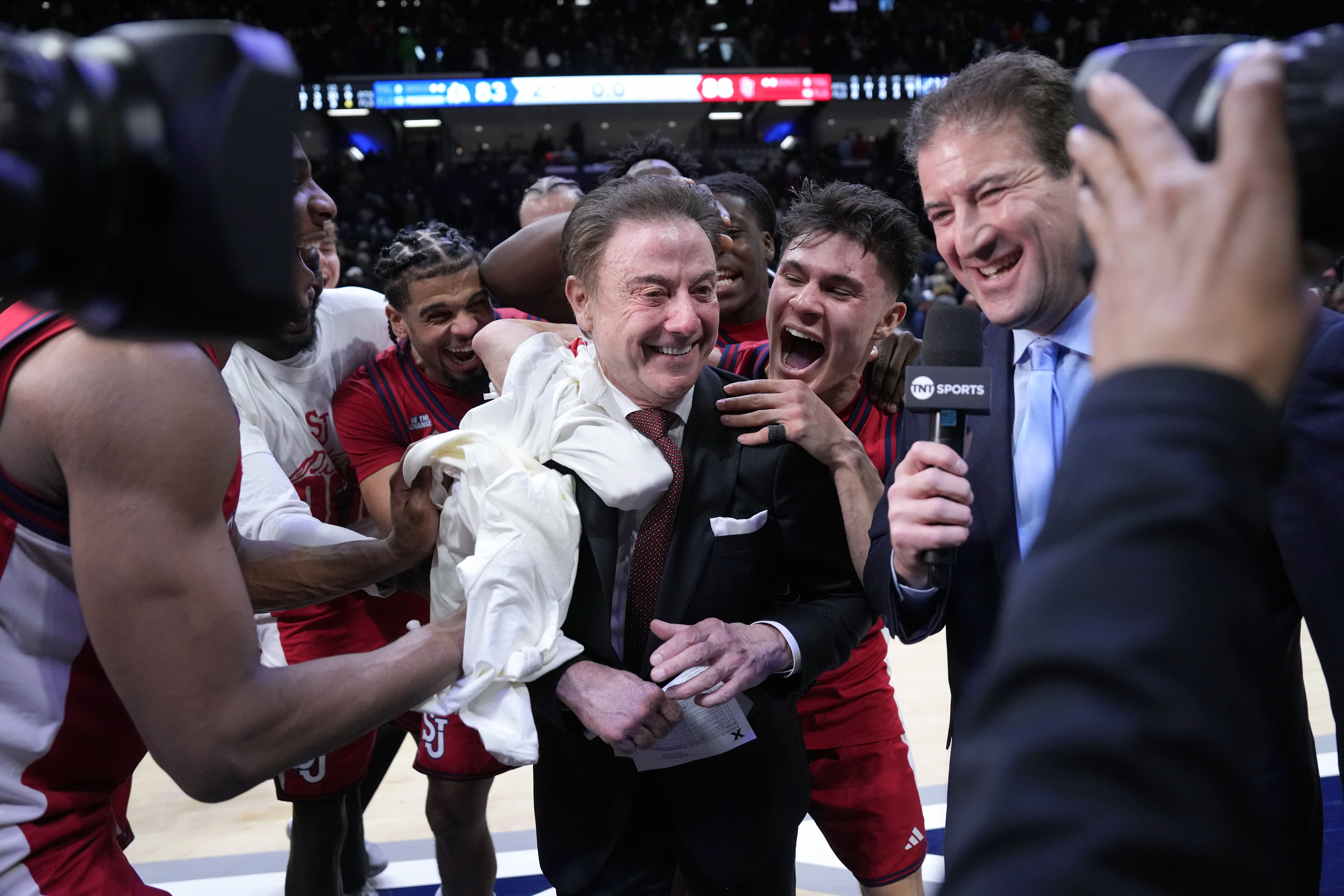 St. John's head coach Rick Pitino, center, is congratulated by his team after earning his 900th career coaching win against Xavier, Saturday, Jan. 24, 2026, in Cincinnati. 