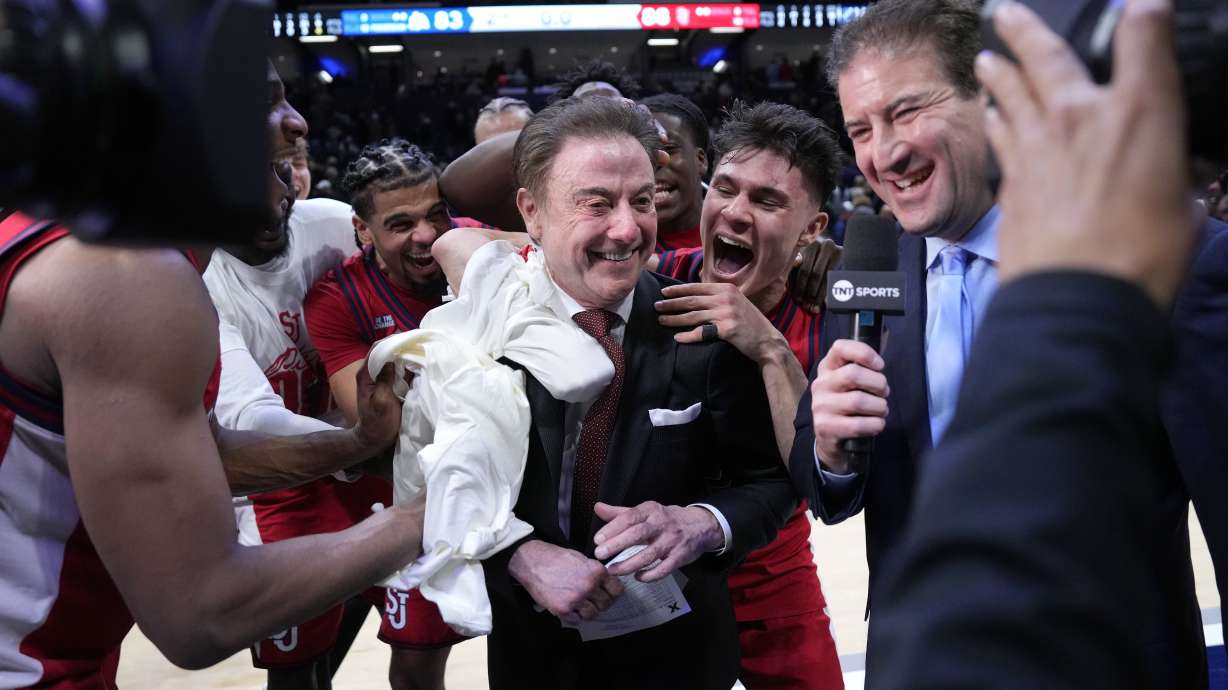 St. John's head coach Rick Pitino, center, is congratulated by his team after earning his 900th career coaching win against Xavier, Saturday, Jan. 24, 2026, in Cincinnati.