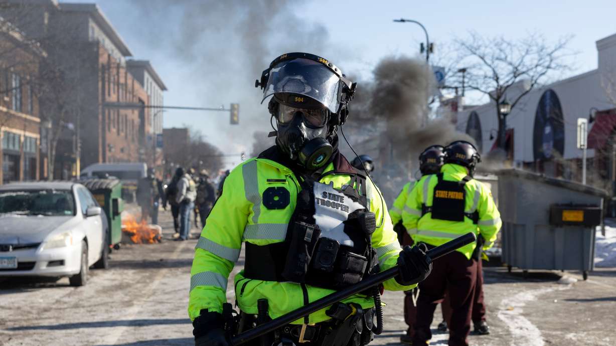 A Minnesota State trooper wears riot gear as protesters fill the site of the fatal shooting of 37-year-old Alex Pretti by federal agents in Minneapolis on Saturday.