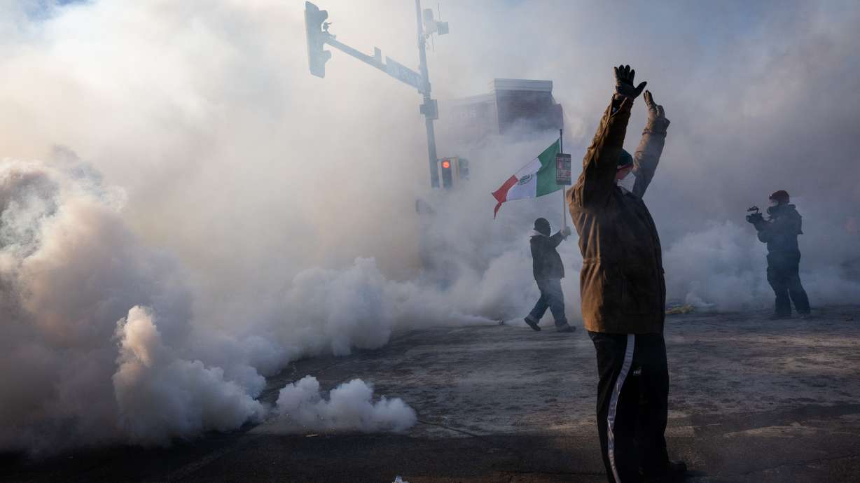 A person holds up their hands as law enforcement deploys a thick screen of teargas on Nicollet Avenue in Minneapolis on Saturday. Democratic officials and protesters on the streets are demanding that federal immigration officers leave Minnesota after a Border Patrol agent fatally shot a man in Minneapolis.