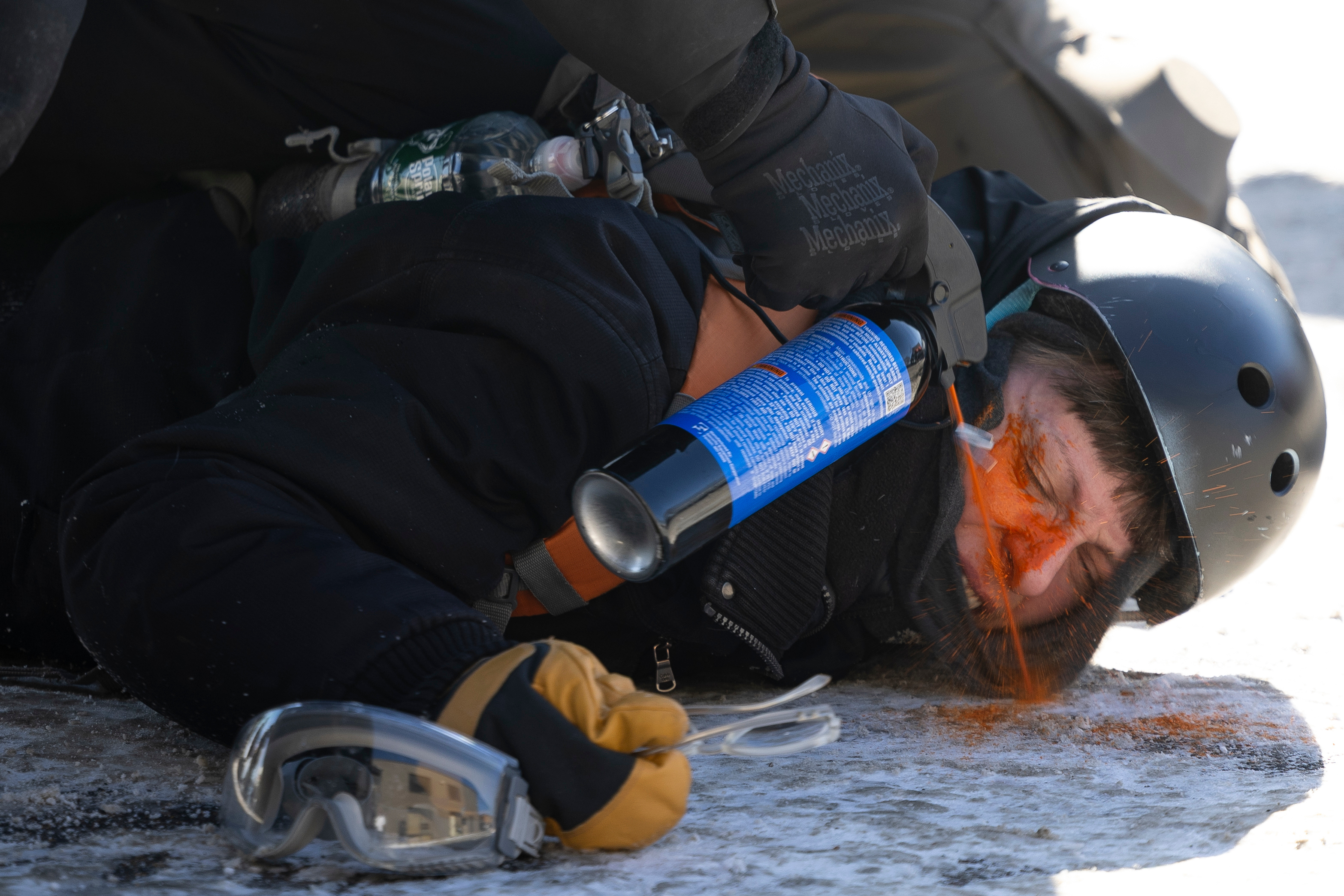 A protester is pepper sprayed at close range while being detained near the site of the fatal shooting of 37-year-old Alex Pretti by federal agents in Minneapolis on Saturday.