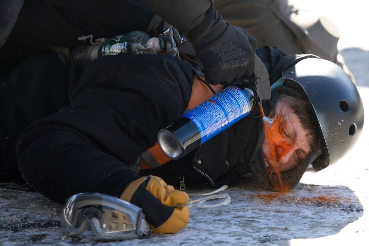 A protester is pepper sprayed at close range while being detained near the site of the fatal shooting of 37-year-old Alex Pretti by federal agents in Minneapolis on Saturday.