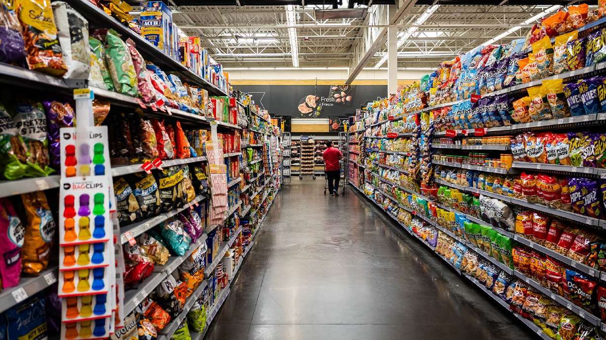 A customer walks in the snack aisle of a Walmart. The chain's private label line is doubling down on wellness products.