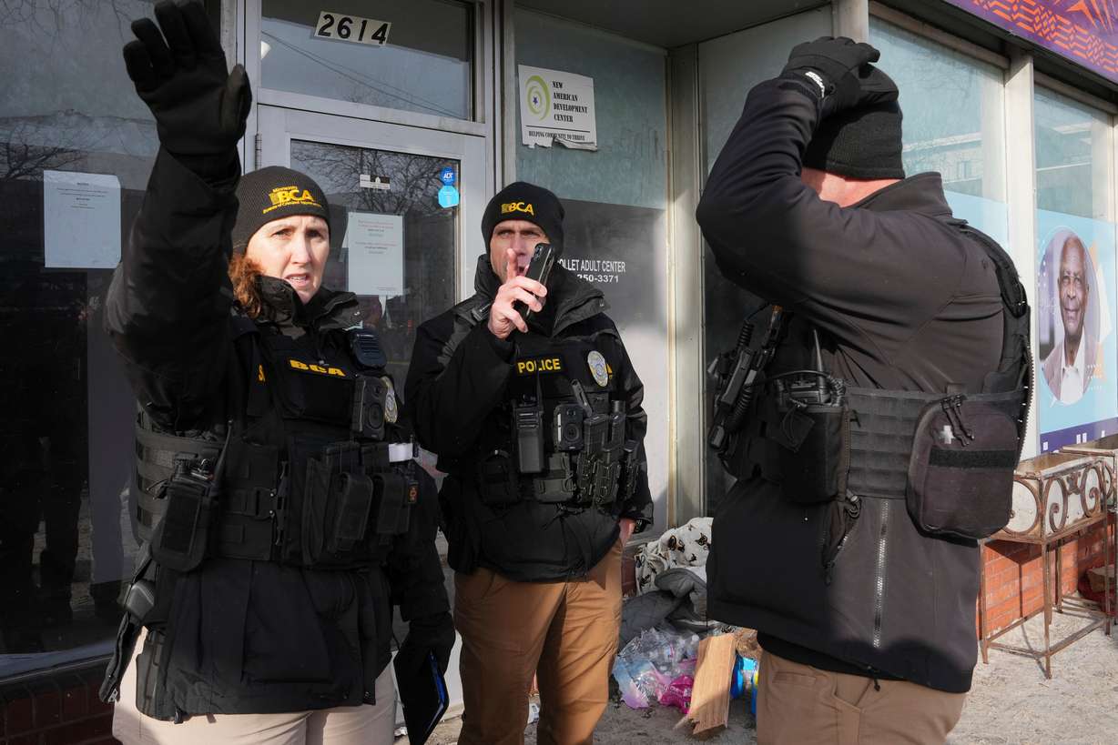 BCA officers stand near the scene of a fatal shooting that took place yesterday, in Minneapolis, Sunday.