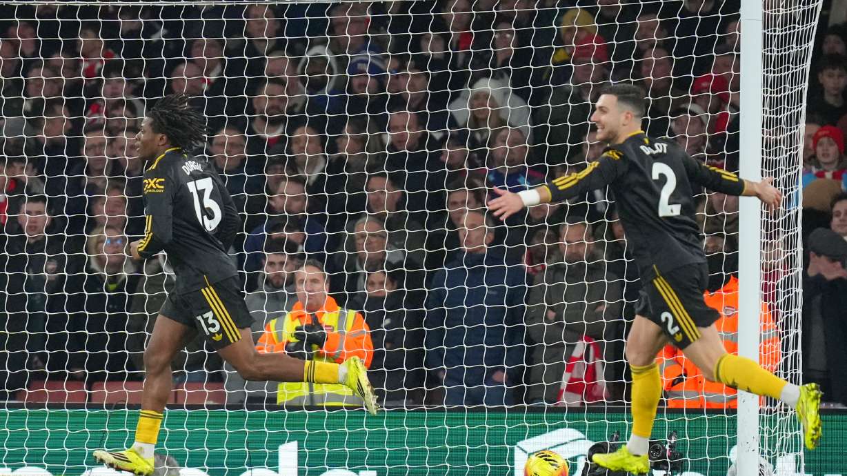 Manchester United's Patrick Dorgu, left, celebrates scoring his side's second goal during the English Premier League soccer match between Arsenal and Manchester United in London, Sunday, Jan. 25, 2026.