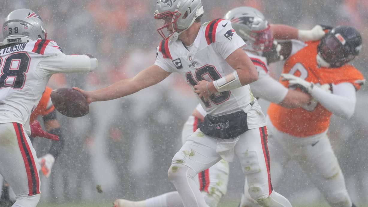 New England Patriots quarterback Drake Maye (10) hands off against the Denver Broncos during the second half of the AFC Championship NFL football game, Sunday, Jan. 25, 2026, in Denver.