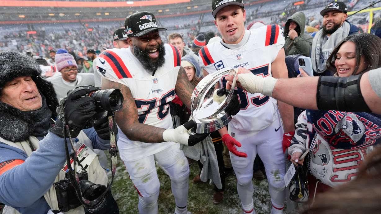 New England Patriots offensive tackle Morgan Moses (76) and tight end Hunter Henry celebrate after the AFC Championship NFL football game against the Denver Broncos, Sunday, Jan. 25, 2026, in Denver.