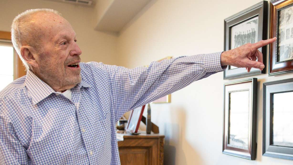 Marvin Melville points to pictures of old United States Olympic teams hanging on the wall at his home in Cottonwood Heights on Dec. 15, 2025.